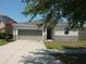 Inviting single-story home with a driveway, two-car garage, and beautiful landscaping at 11527 Southern Creek Dr, Gibsonton, FL 33534
