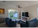 Bright living room featuring comfortable sofas, a ceiling fan, and sliding glass doors to the backyard at 11527 Southern Creek Dr, Gibsonton, FL 33534
