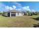 Wide grassy backyard with a home featuring a screened-in porch under a bright sky at 12310 Streambed Dr, Riverview, FL 33579