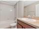 This bathroom has a tub-shower combination with white tile, a sink and dark wood vanity at 12310 Streambed Dr, Riverview, FL 33579