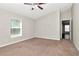 This bedroom has neutral walls, a window, a ceiling fan, and neutral color carpet at 12310 Streambed Dr, Riverview, FL 33579
