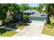 Aerial view of home highlighting roof, circular windows, two car garage, and mature landscaping at 12920 Lake Ventana Dr, Tampa, FL 33625