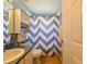 Well-lit bathroom featuring a toilet, vanity, and a shower with a stylish chevron-patterned curtain at 12920 Lake Ventana Dr, Tampa, FL 33625