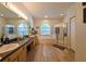 Spa-like main bathroom with dual sinks, soaking tub, glass-enclosed shower, and wood-look flooring at 12920 Lake Ventana Dr, Tampa, FL 33625