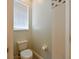 Simple half-bathroom with a toilet, storage cabinet, and small window for natural light at 12920 Lake Ventana Dr, Tampa, FL 33625