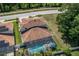 Aerial view of a home with a screened-in pool, surrounded by a well-maintained lawn and mature trees at 13008 Eagles Entry Dr, Odessa, FL 33556