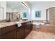A primary bathroom with double granite vanity, soaking tub, and glass-enclosed shower at 13008 Eagles Entry Dr, Odessa, FL 33556