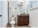 Bathroom features dark wood vanity with stone countertop, a white toilet, and a shower at 13008 Eagles Entry Dr, Odessa, FL 33556