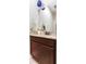 A half bathroom features a granite countertop and dark wood cabinetry at 13008 Eagles Entry Dr, Odessa, FL 33556