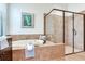 The bathroom has a soaking tub and walk-in shower with neutral-colored tile at 13008 Eagles Entry Dr, Odessa, FL 33556