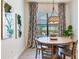 Cozy dining area with a round table, modern chandelier, and backyard view at 13008 Eagles Entry Dr, Odessa, FL 33556