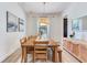 Bright dining room with a long wooden table and a decorative light fixture over the table at 13008 Eagles Entry Dr, Odessa, FL 33556