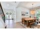 Bright dining room with a wooden table, a large window, and staircase with elegant iron railings at 13008 Eagles Entry Dr, Odessa, FL 33556