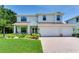 Charming two-story home with a well-manicured lawn and a three-car garage at 13008 Eagles Entry Dr, Odessa, FL 33556