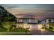 Two-story home with a three-car garage, mature trees, and manicured lawn at 13008 Eagles Entry Dr, Odessa, FL 33556