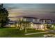 Beautiful two-story home with lush green lawn and professional landscaping at dusk at 13008 Eagles Entry Dr, Odessa, FL 33556