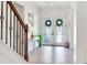Bright foyer featuring double doors with decorative wreaths and a staircase with elegant iron railings at 13008 Eagles Entry Dr, Odessa, FL 33556