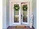Elegant double front doors with decorative wreaths and a 'Welcome' mat at 13008 Eagles Entry Dr, Odessa, FL 33556
