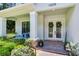 Inviting front porch with cozy seating and decorative wreaths on the double doors at 13008 Eagles Entry Dr, Odessa, FL 33556
