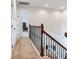 Hallway with carpeted floors and wrought iron railing overlooking the entry, complemented by white walls and doors at 13008 Eagles Entry Dr, Odessa, FL 33556