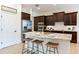 Modern kitchen featuring dark cabinets, stainless steel appliances, and a granite island with barstool seating at 13008 Eagles Entry Dr, Odessa, FL 33556