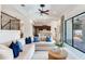 Spacious living room with a modern sofa, access to the kitchen, and staircase with wrought iron railings at 13008 Eagles Entry Dr, Odessa, FL 33556