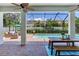 Covered patio features outdoor seating, a dining table, and a view of the pool and lush landscaping at 13008 Eagles Entry Dr, Odessa, FL 33556