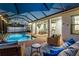 Outdoor living space featuring a screened-in pool, covered patio, and comfortable seating at 13008 Eagles Entry Dr, Odessa, FL 33556