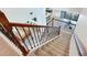 Carpeted staircase with decorative metal railing leading to an open-concept living space with wood floors at 13008 Eagles Entry Dr, Odessa, FL 33556
