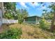 Green house with chain link fence and greenery in backyard at 1308 W Perdiz St, Tampa, FL 33612