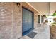 Close up of inviting entryway with double blue doors, brick facade, and modern sconces at 1308 W Perdiz St, Tampa, FL 33612