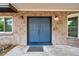 Inviting entryway with double blue doors, brick facade, and modern sconces at 1308 W Perdiz St, Tampa, FL 33612