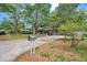 Single-Gathering home with a brick exterior, mature trees, landscaping, and a paved driveway at 1308 W Perdiz St, Tampa, FL 33612