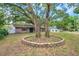 Charming brick home with mature trees and a circular brick planter in the front yard at 1308 W Perdiz St, Tampa, FL 33612
