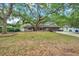 Charming brick home featuring a lovely, large tree, well-maintained lawn and an attached two-car garage at 1308 W Perdiz St, Tampa, FL 33612