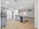 Open kitchen with island, granite countertops, stainless appliances, and tan tile flooring at 1308 W Perdiz St, Tampa, FL 33612