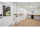 Large utility room with a door to the exterior, lots of workspace, and neutral tile floors at 1308 W Perdiz St, Tampa, FL 33612