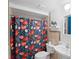 Cozy bathroom featuring a colorful shower curtain and well-placed shelving for toiletries at 1424 Castleworks Ln, Tarpon Springs, FL 34689