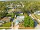 Aerial view of a cozy home featuring a private pool, mature trees, and well-maintained landscaping in a quiet neighborhood at 1596 Idle Dr, Clearwater, FL 33756