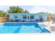 Backyard pool with patio, perfect for relaxing and entertaining, complements the blue exterior of the home at 1596 Idle Dr, Clearwater, FL 33756