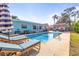 Inviting backyard pool with lounge chairs, lush landscaping, and a charming mural on the storage shed at 1596 Idle Dr, Clearwater, FL 33756