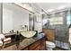 Bathroom with a glass vessel sink, granite countertop, and a walk-in shower with modern fixtures at 1596 Idle Dr, Clearwater, FL 33756