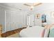 Bright bedroom featuring a ceiling fan, wood floors, and ample closet space for organized storage at 1596 Idle Dr, Clearwater, FL 33756