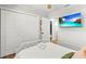 This bright bedroom features ample closet space and a beach view television at 1596 Idle Dr, Clearwater, FL 33756