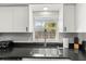 Bright kitchen with stainless steel sink and fixtures, enhanced by natural light from the window at 1596 Idle Dr, Clearwater, FL 33756