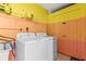 Laundry room featuring a white washer and dryer, storage shelves and bright two-toned walls at 1596 Idle Dr, Clearwater, FL 33756