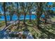 Expansive backyard featuring lush greenery, mature trees, and a deck with picturesque lake views, ideal for outdoor entertaining at 16019 Chastain Rd, Odessa, FL 33556
