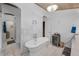 Bright bathroom featuring a standalone tub, marble tile, and modern fixtures at 16019 Chastain Rd, Odessa, FL 33556