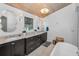 Elegant bathroom featuring dual sinks with marble countertops, dark wood cabinets, and a soaking tub at 16019 Chastain Rd, Odessa, FL 33556