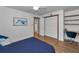 Bedroom with wood floors, white walls, closet, desk area, and natural lighting at 16019 Chastain Rd, Odessa, FL 33556